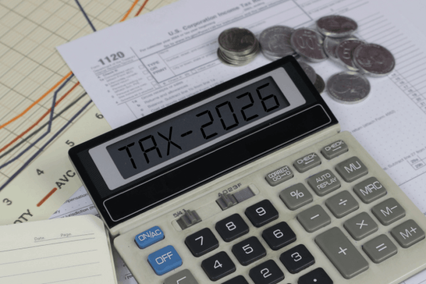 Calculator displaying TAX-2026 surrounded by IRS Form 1120 and coins — illustrating what are the odds of being audited by the IRS in 2026