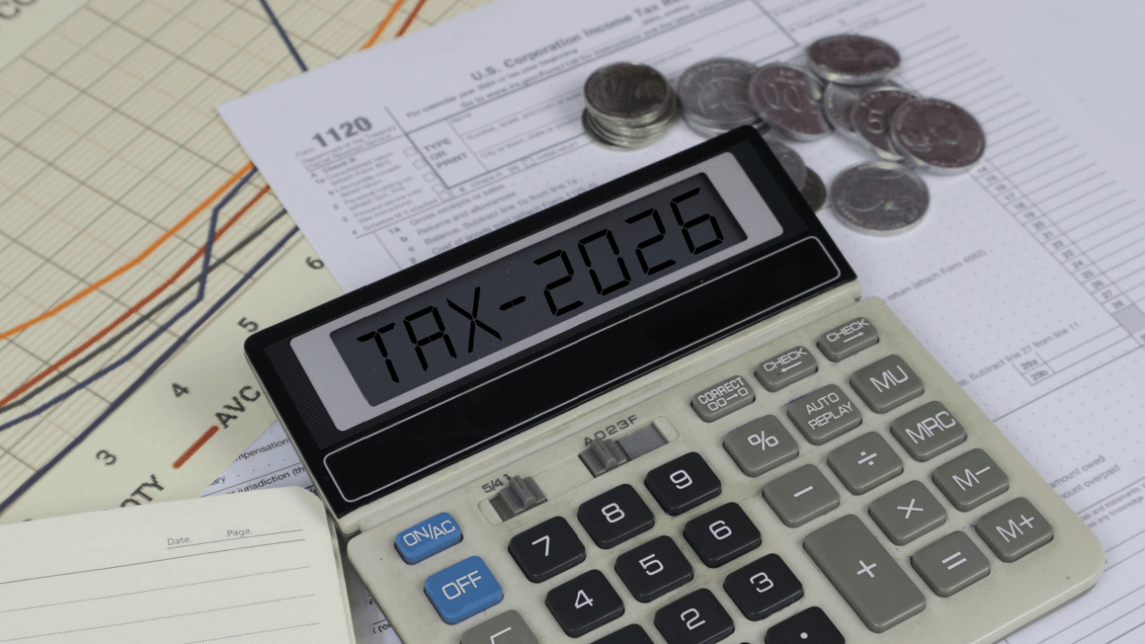 Calculator displaying TAX-2026 surrounded by IRS Form 1120 and coins — illustrating what are the odds of being audited by the IRS in 2026