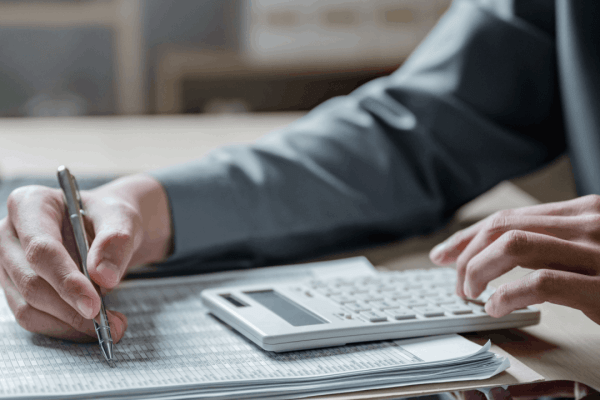 What happens when your taxes are audited — a tax professional reviewing financial documents and calculating figures on behalf of a client