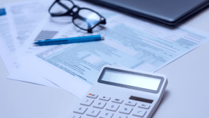 What is the fine if you get audited — calculator, tax documents, glasses, and pen on a desk representing IRS audit penalty review