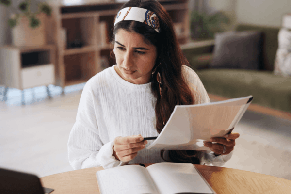 Woman reviewing IRS tax debt documents at home desk