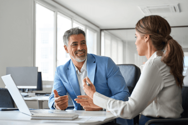 Professional advisor explaining what triggers a tax audit to a concerned business client in a modern office setting