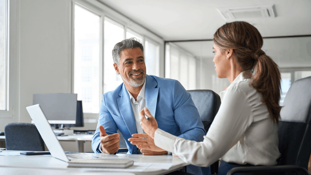Professional advisor explaining what triggers a tax audit to a concerned business client in a modern office setting