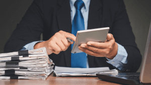Tax professional reviewing financial documents and using a calculator to assess IRS audit risk for who gets audited the most by the IRS