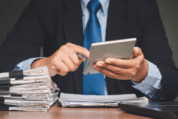 Tax professional reviewing financial documents and using a calculator to assess IRS audit risk for who gets audited the most by the IRS
