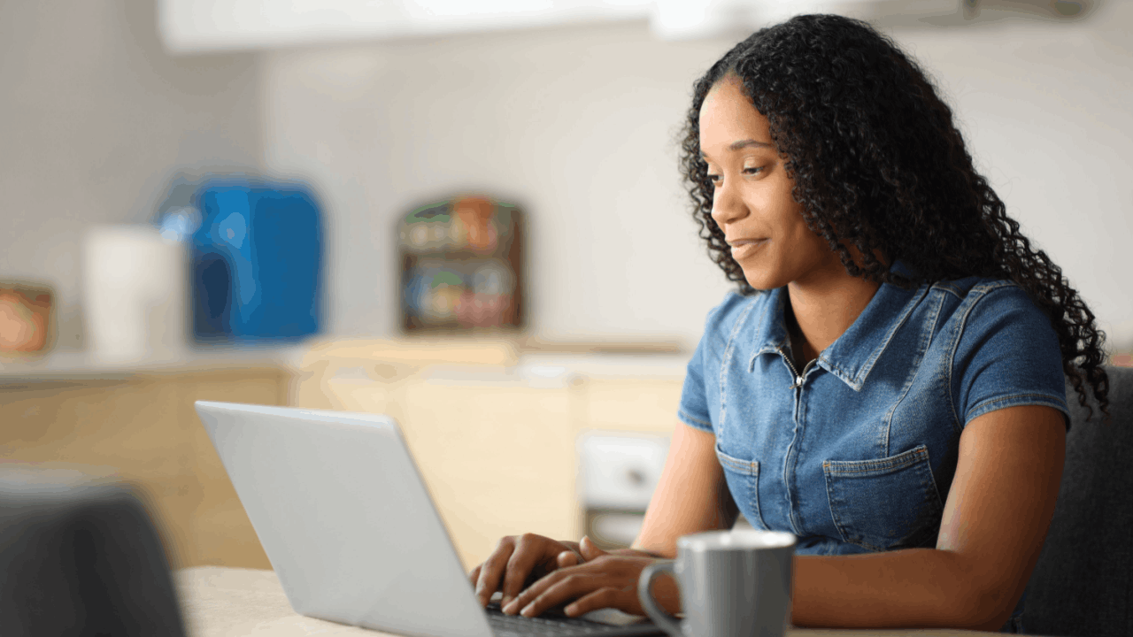 Bonus depreciation – woman smiling while researching business tax deductions on a laptop at home