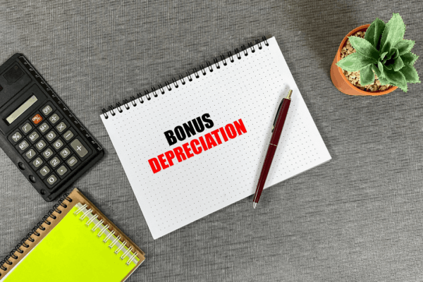 Bonus depreciation phase out guide for business owners with calculator and notebook