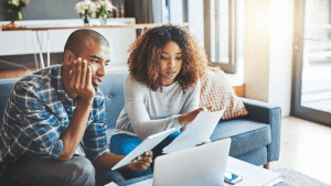 A couple reviews tax documents and IRS notices together at home, researching what is the 2 year rule for audit and their options for tax debt relief. What is the 2 year rule for audit — couple reviewing IRS tax documents at home
