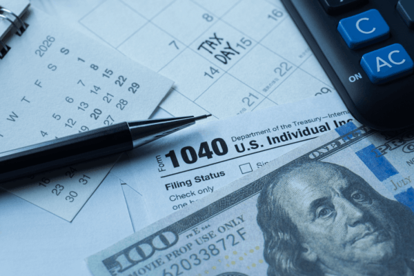Bonus depreciation tax planning documents with Form 1040, calculator, and cash on Tax Day calendar