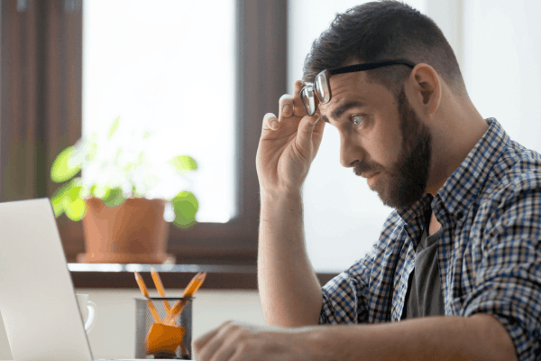 Man stressed reviewing common bonus depreciation mistakes on laptop