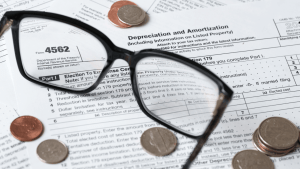 Section 179 carryforward rules shown on IRS Form 4562 with coins and glasses