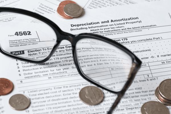 Section 179 carryforward rules shown on IRS Form 4562 with coins and glasses
