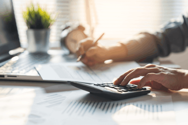 Section 179 vs bonus depreciation rules — business owner calculating tax deductions at desk