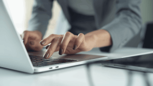 Professional typing on a laptop to research the IRS hardship program wage garnishment relief options