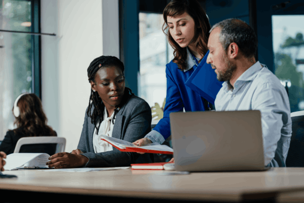 Three professionals reviewing financial documents together discussing whether can IRS garnish self employed income