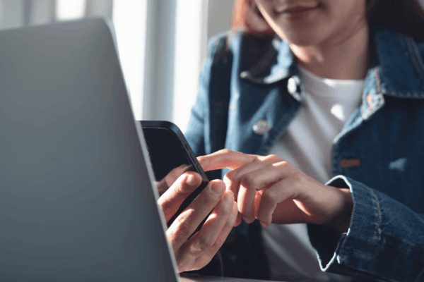 Woman using a phone and laptop to find out how long does garnishment release take IRS