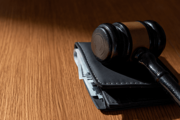 Gavel resting on a wallet with cash illustrating how much can IRS garnish wages from a paycheck