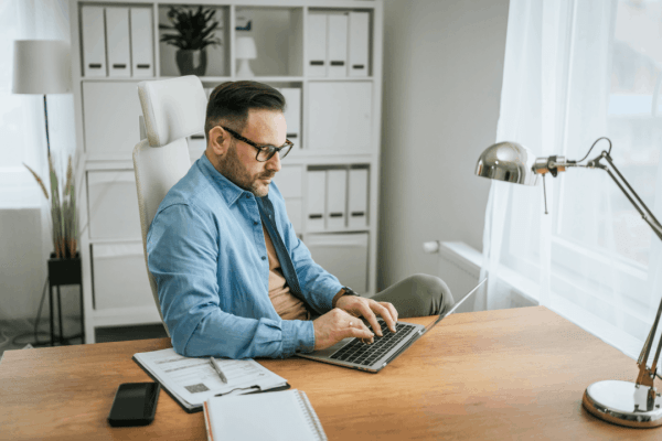 Man working at a desk on a laptop researching IRS garnishment percentage limits for his wages